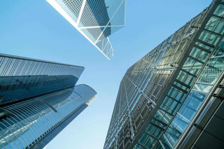 Upward view of modern glass office towers against a clear sky, illustrating Australia’s commercial property market in 2025.