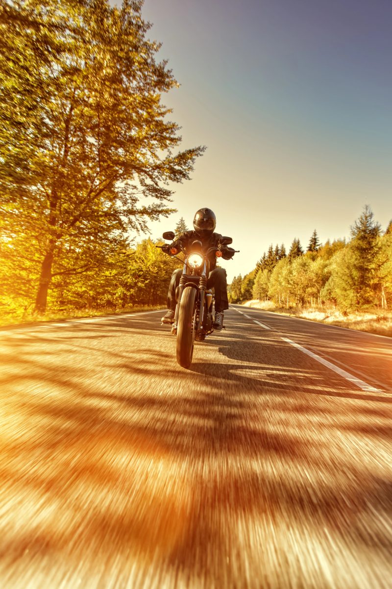 Motorbike rider on a country road in Victoria, Australia at sunset after arranging finance through a motorbike finance broker