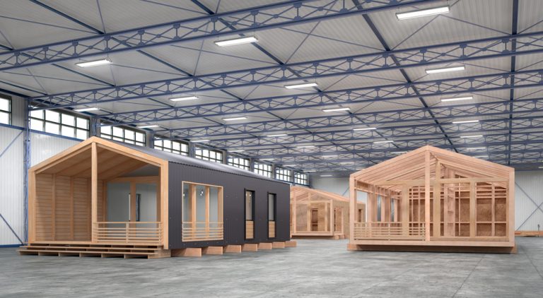 Factory floor with a timber tiny home under construction inside a modern warehouse — off-site build in Australia