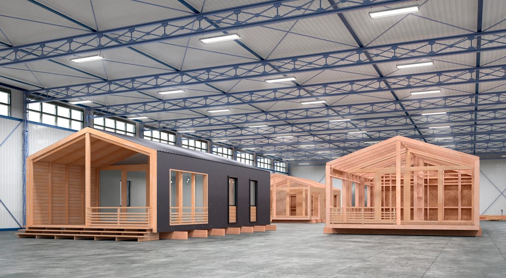 Factory floor with a timber tiny home under construction inside a modern warehouse — off-site build in Australia