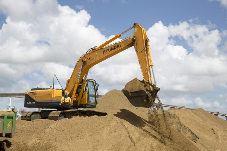Yellow excavator on a construction site showing how earthmoving gear can secure equipment finance.