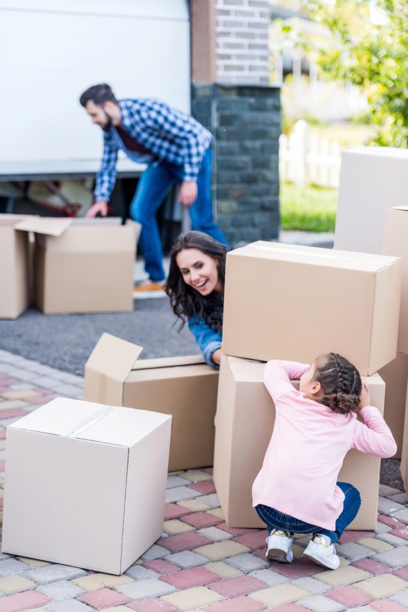 Family with moving boxes outside their new home in Southport QLD 2025
