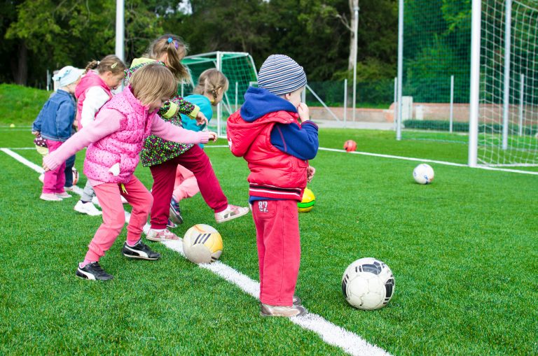 Children playing soccer outdoors, showing active play in Geelong childcare and kindergarten programs.