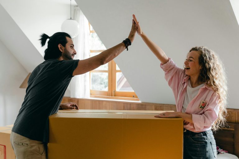 Young couple high-fiving on moving day in Delacombe VIC 3356 (2025 property report)